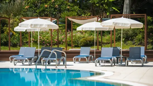 Pool med solstole og parasoller 