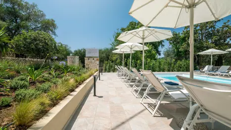 Poolområde med solstole og parasoller 
