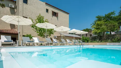 Poolområde med solstole og parasoller 
