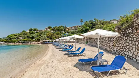 Privat strand med solstole og parasoller