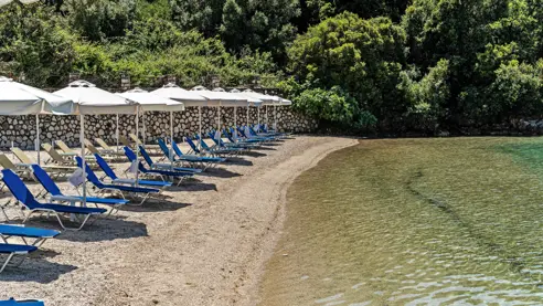 Privat strand med solstole og parasoller