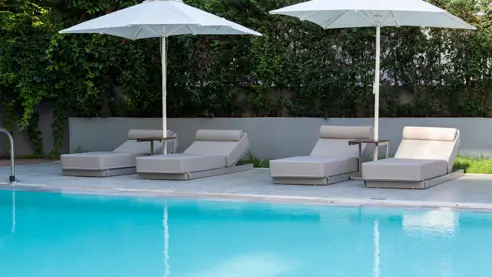Pool med solstole og parasoller 