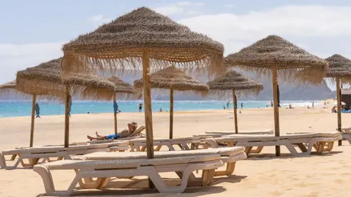 Solstole og parasoller på stranden 