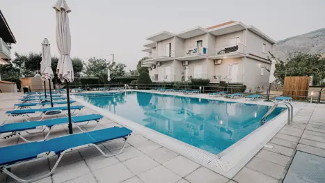 Poolområde med solstole og parasoller 