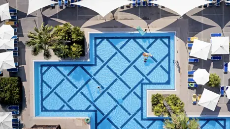 Pool med solstole og parasoller 