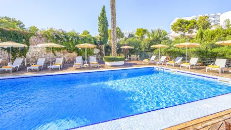 Poolområde med solstole og parasoller 