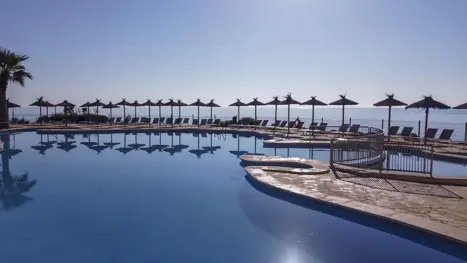 Pool med solstole og parasoller 