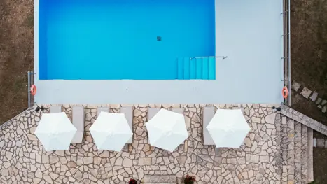 Poolområde med solstole og parasoller 