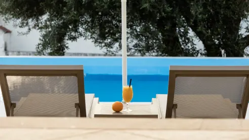 Poolområde med solstole og parasoller 