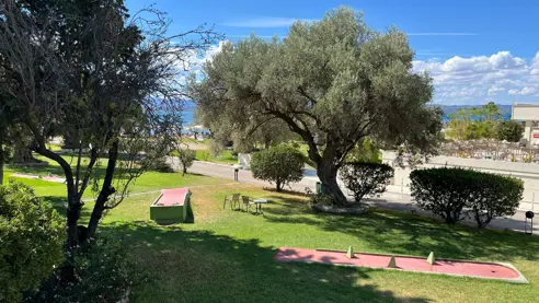 Skøn have med oliventræer og minigolf