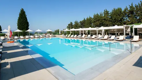 Swimmingpool med solsenge og parasoller