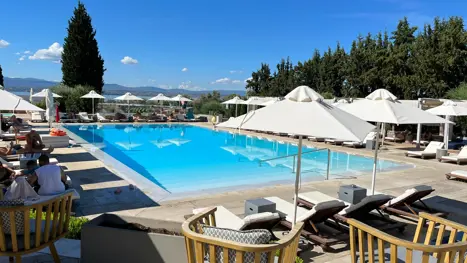 Swimmingpool med solsenge og parasoller