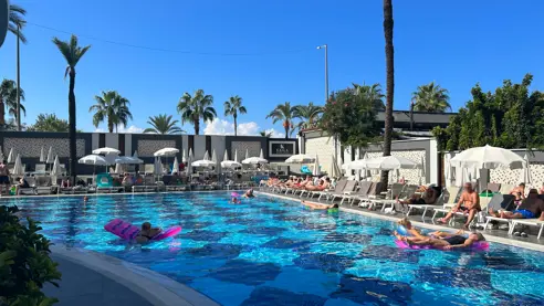 Poolområde med solsenge og parasoller