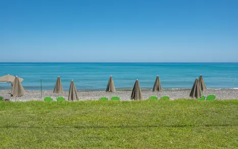 Strand med liggestole og parasoller