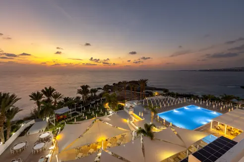 Solnedgang over solterrasse og pool