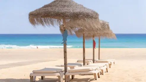Solstole og parasoller på stranden 