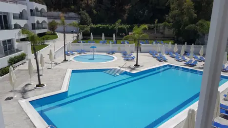 Poolområde med solstole og parasoller 