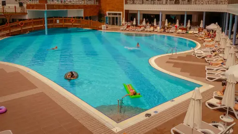 Poolområde med solstole og parasoller 